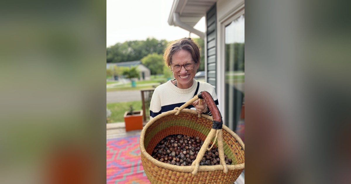 Lisa M. Rose holding a basket of gathered acorns