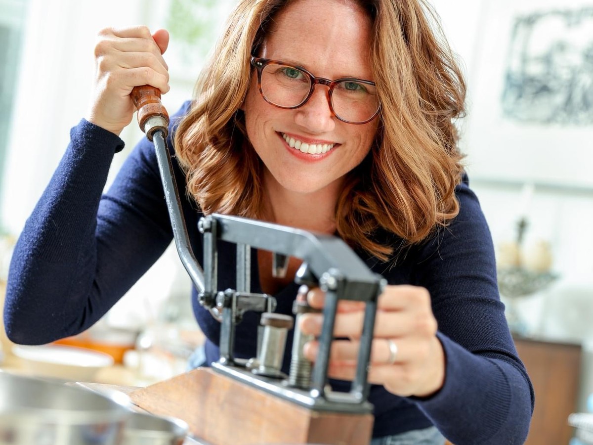 Lisa M. Rose shelling acorns with a hand-cranked acorn cracker